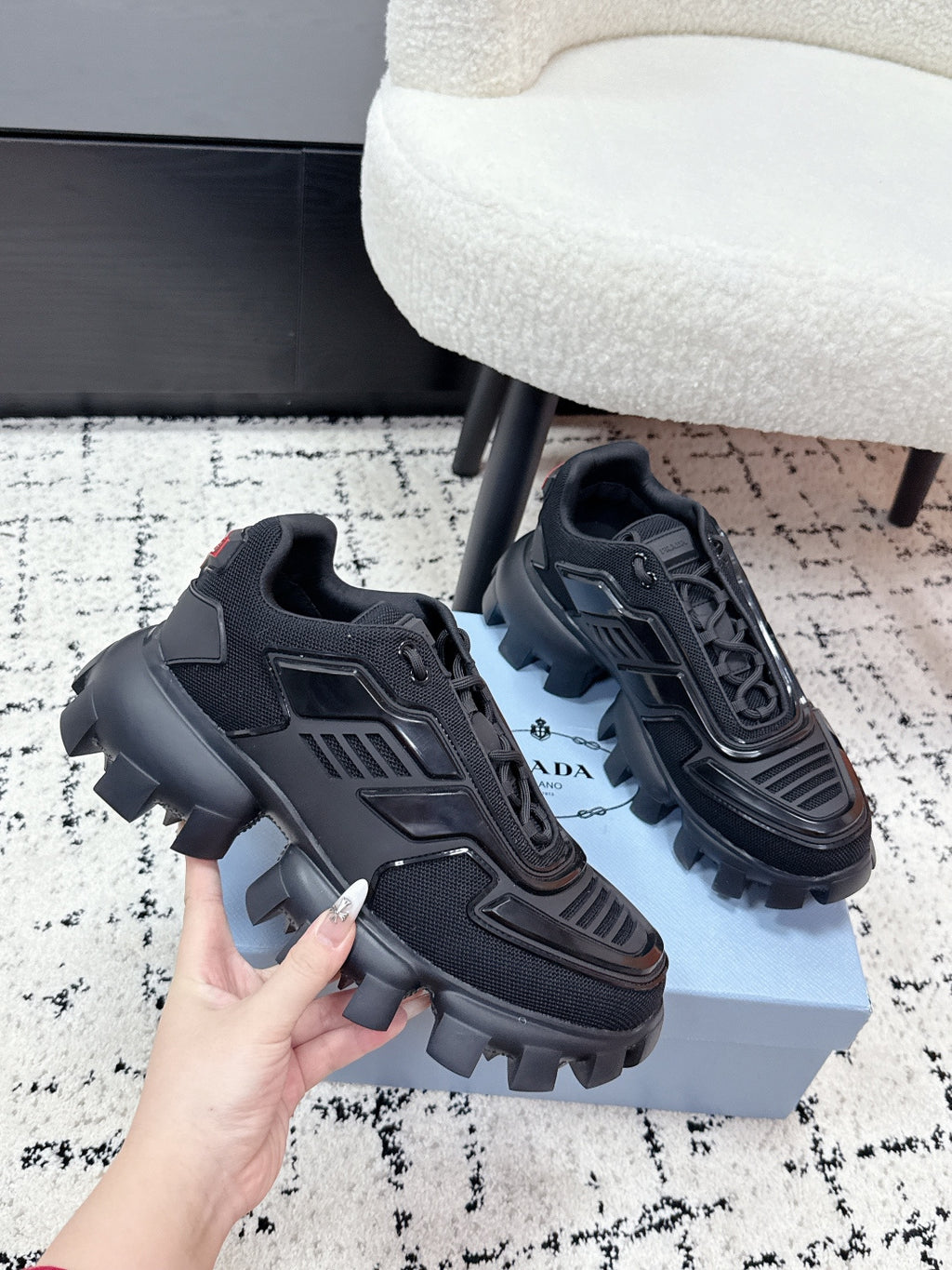 Prada unisex sneakers, black, angled side view with textured panels and rugged sole