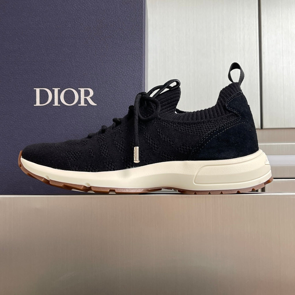 Black knit sneaker, lace-up style with white midsole and Dior branding on side.