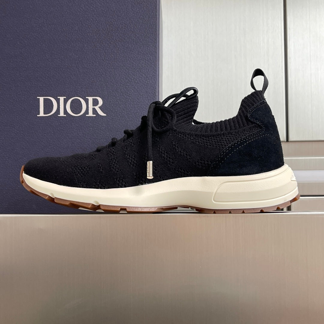 Black knit sneaker, lace-up style with white midsole and Dior branding on side.