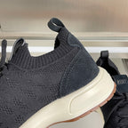 Close-up of black knit sneaker upper with cream midsole and brown outsole edge.