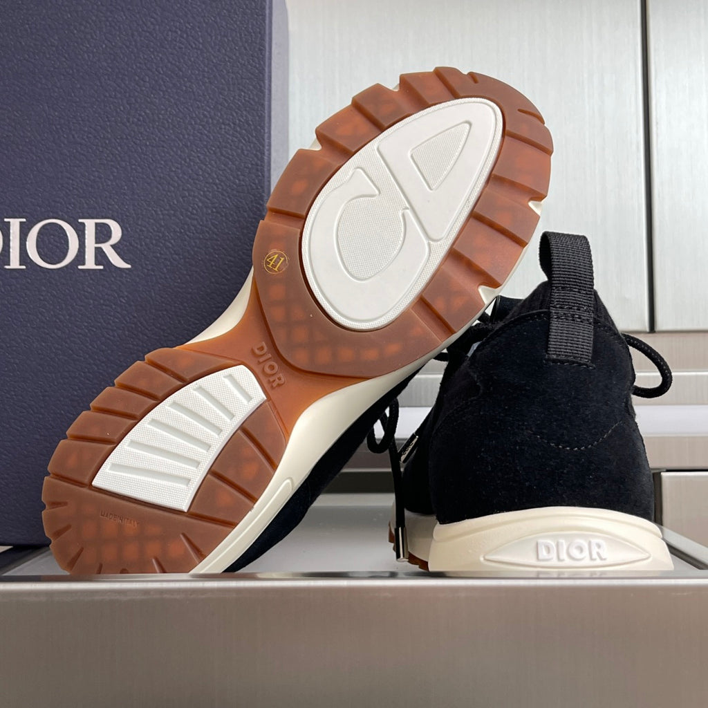 Dior black knit sneakers with rugged brown rubber outsole tread.