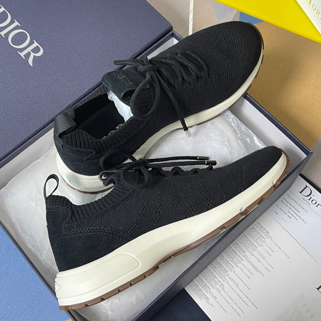 Black knit sneakers with laces, cream sole, and Dior label on tongue.