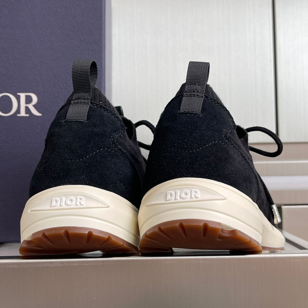Black sneakers with white tread soles, lace-up collar and Dior heel tab.