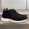 Black knit sneaker with lace-up front and white sole, Dior logo on tongue.