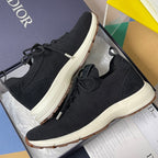 Black knit sneakers with lace-up closure and white rubber sole, Dior on side.