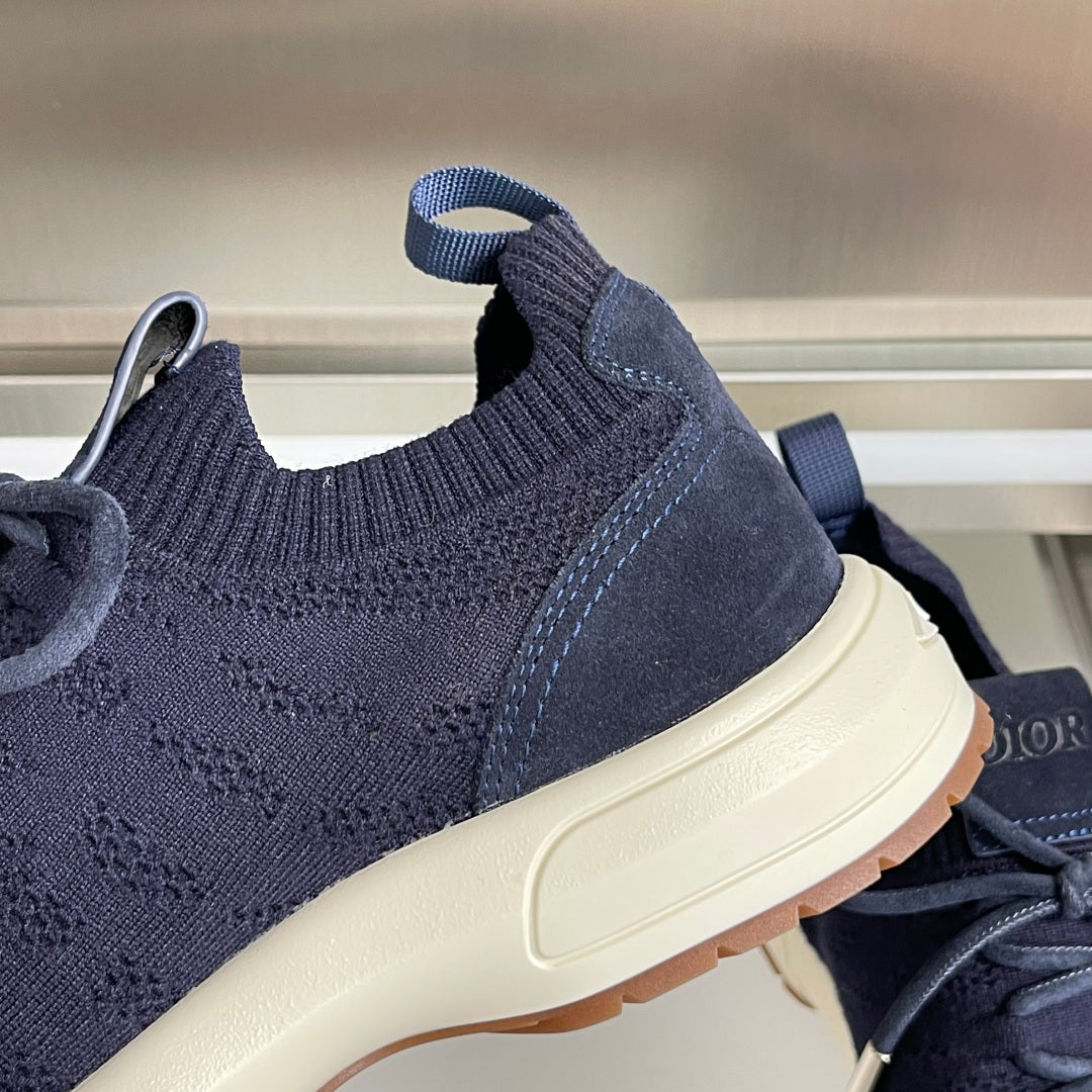 Close-up of dark navy unisex knit sneaker side with lace-up and white sole