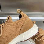 Tan unisex sneaker close-up with knit collar, suede side panel, and white sole