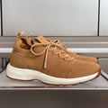 Tan unisex sneakers with knit upper, lace-up front, and white rubber sole