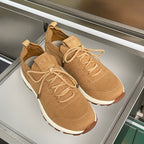 Pair of tan unisex sneakers with lace-up knit design and thick white sole