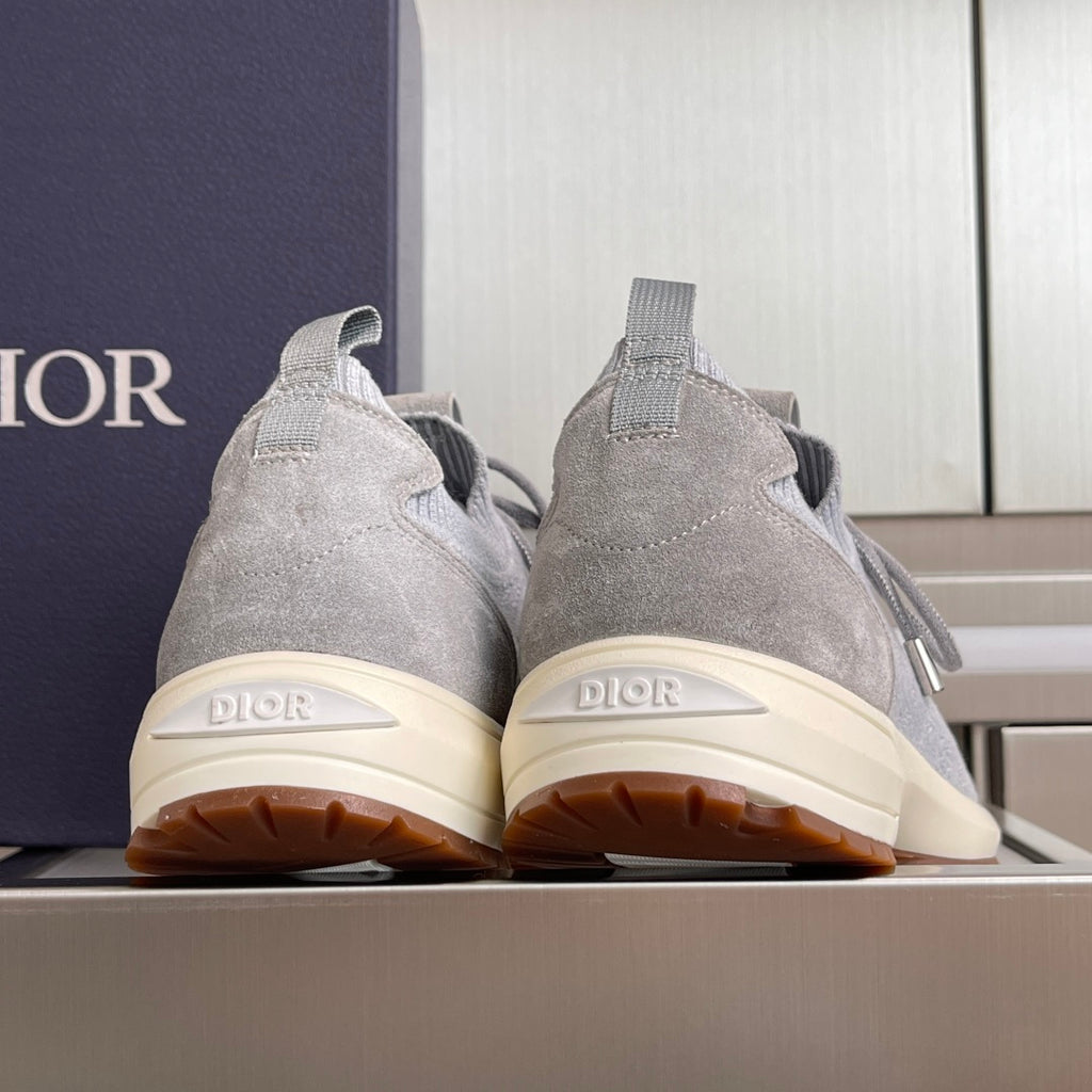 Back view of light grey knit sneakers with cream outsole, Dior heel logo and tag