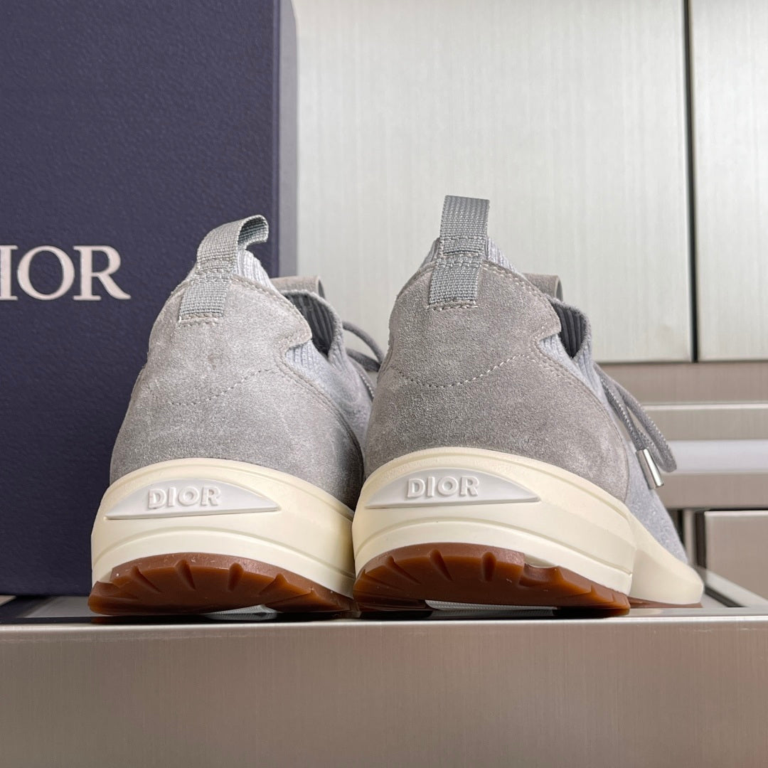 Back view of light grey knit sneakers with cream outsole, Dior heel logo and tag