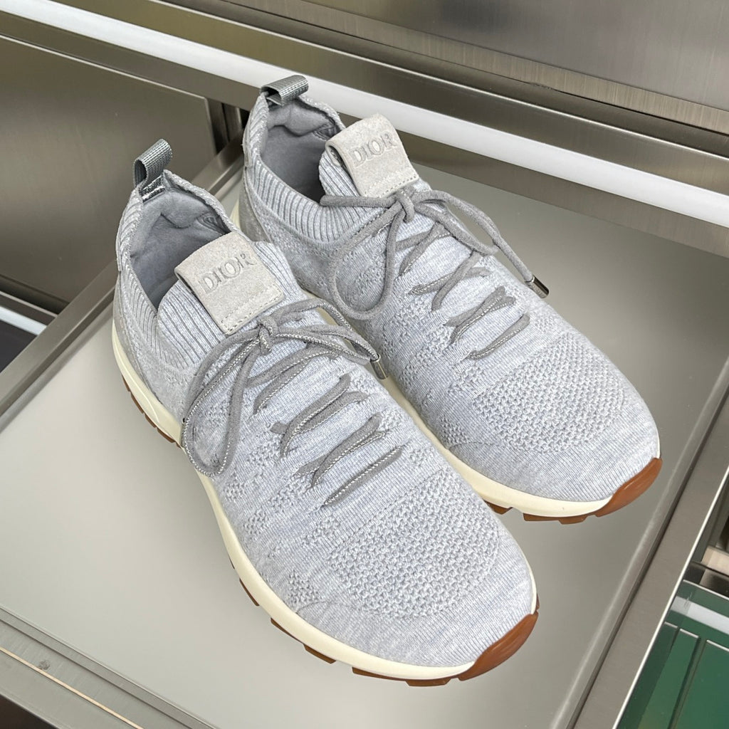 Pair of light grey knit sneakers with lace-up front, cream sole and Dior heel logo