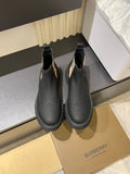 Black leather Chelsea boots with check-panel side detail and tread sole