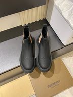Black leather Chelsea boots with check-panel side detail and tread sole
