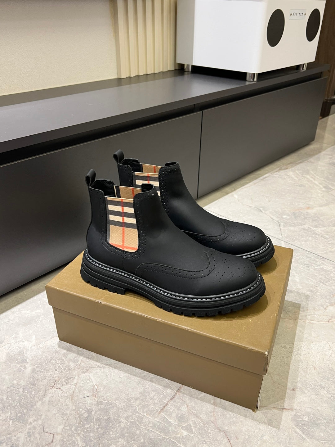 Black leather Chelsea boots with check-panel gore and chunky stitched tread sole