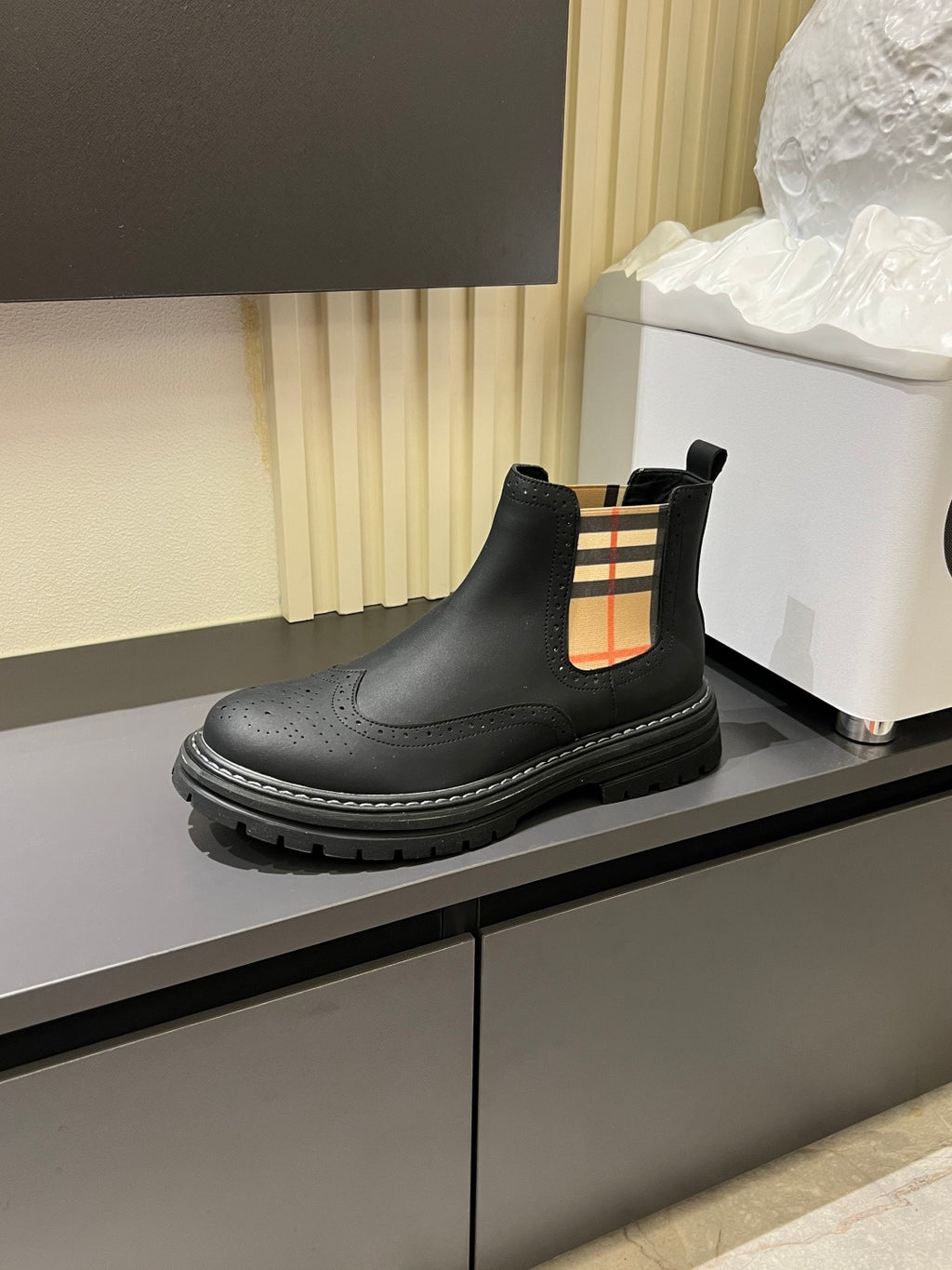 Black leather Chelsea boot with check-panel side detail and thick tread sole