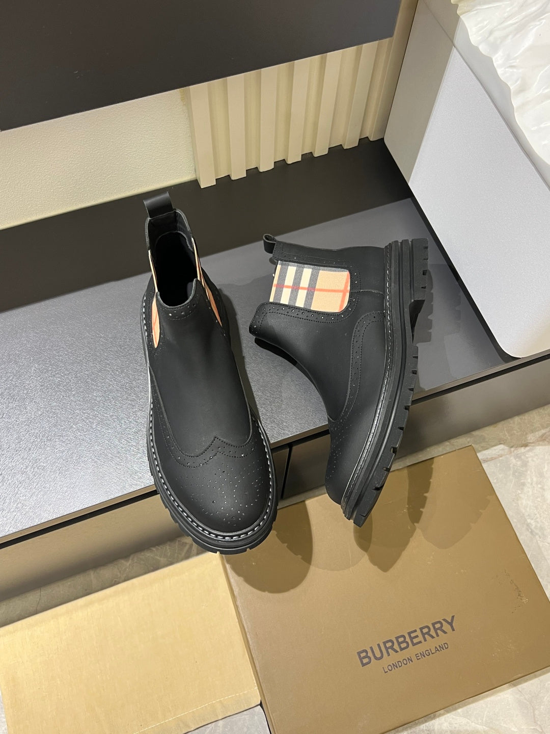 Black leather Chelsea boots with check-panel gore and stitched edge tread sole