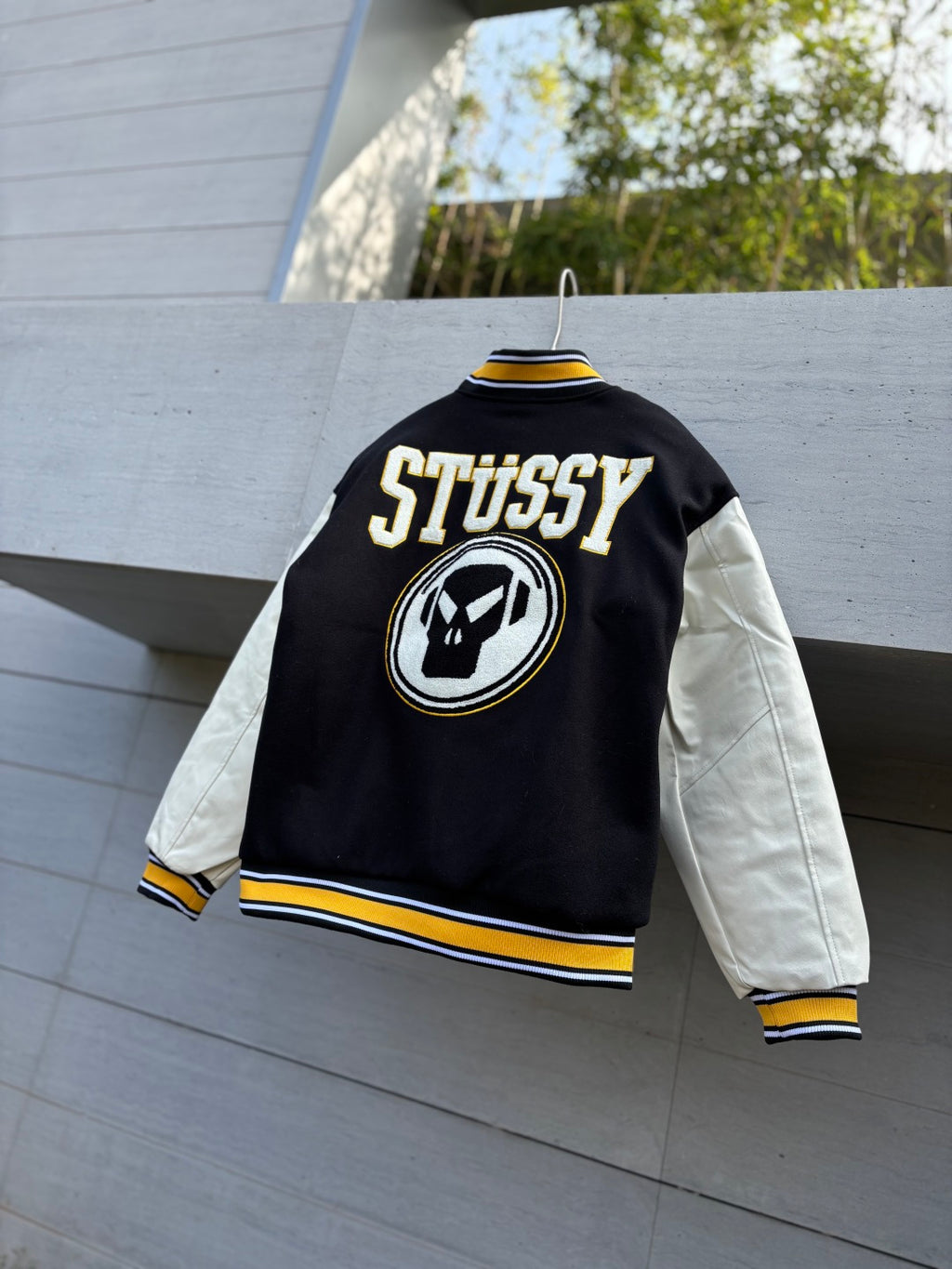 Varsity jacket with black back panel, STUSSY logo patch, striped hem and cuffs