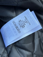 Black quilted jacket fabric label with quilt stitch detail