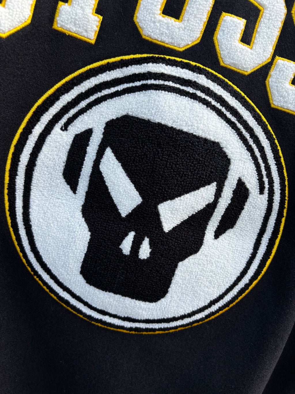 Black sweatshirt with circular logo and black-and-white face graphic
