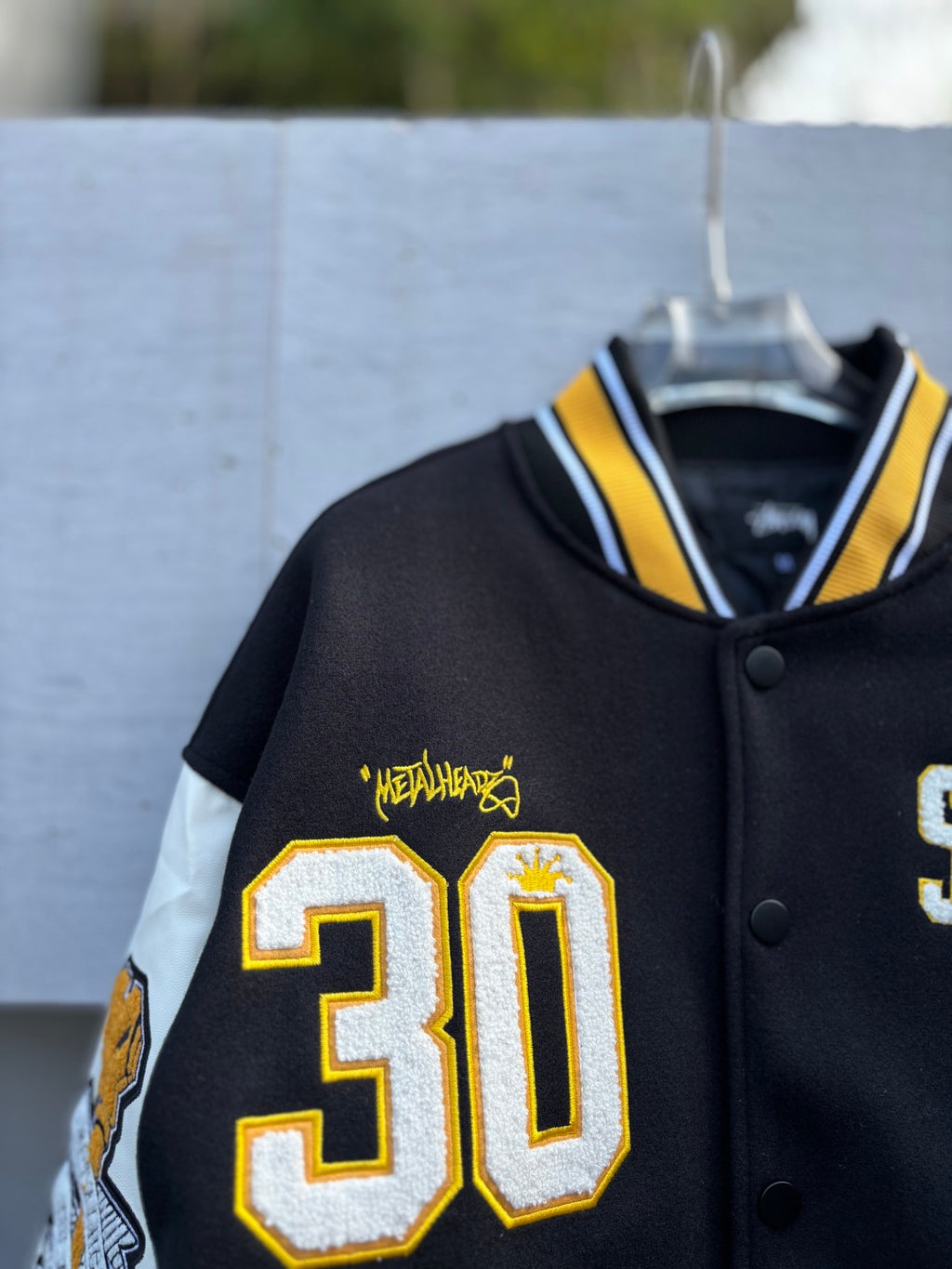 Varsity jacket with 30 patch and yellow Metalhead graphic on black front