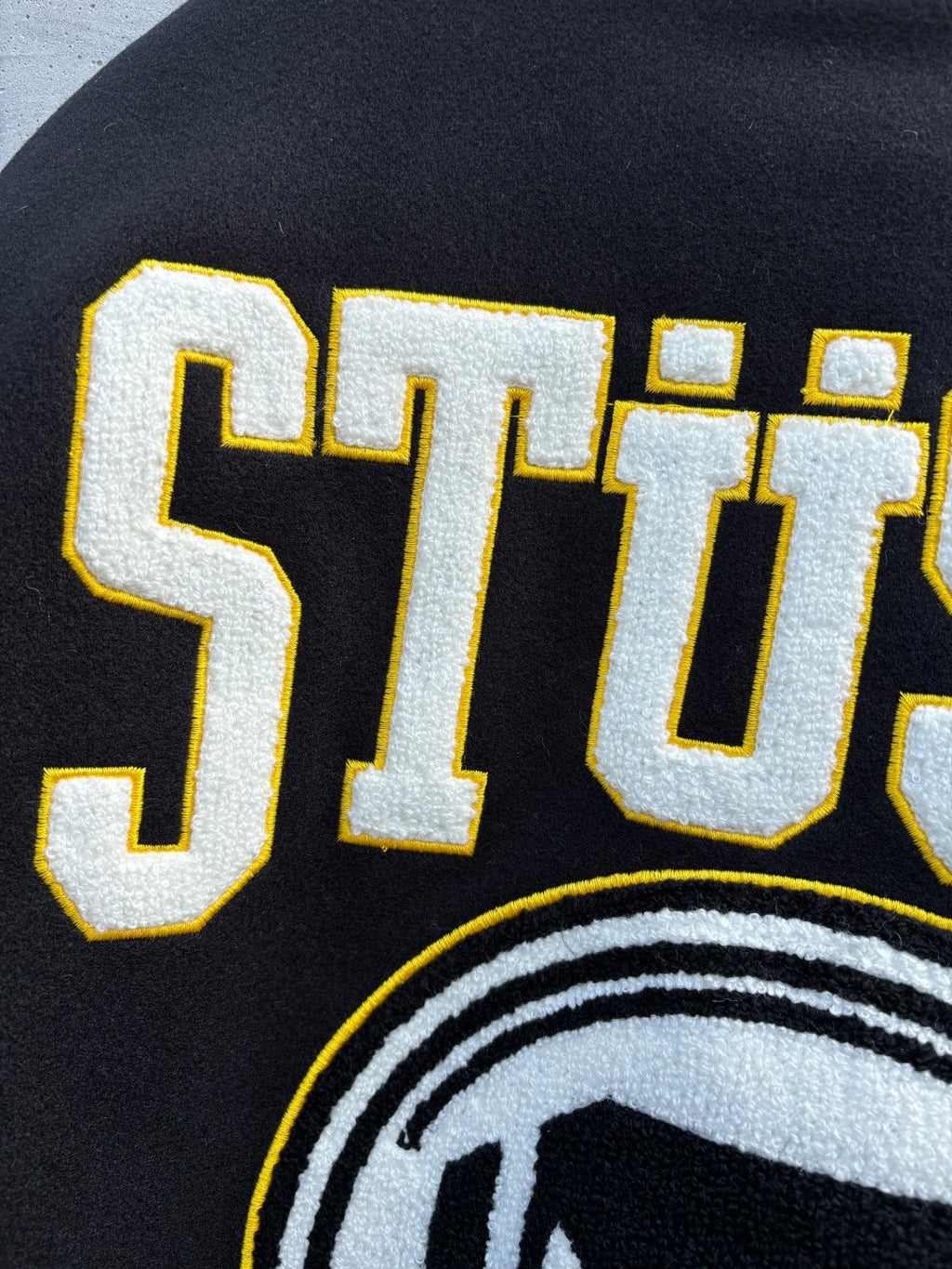 Black sweatshirt with STUSSY lettering and partial circular logo print