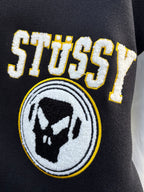 Black varsity jacket embroidered Stussy logo patch and bear emblem