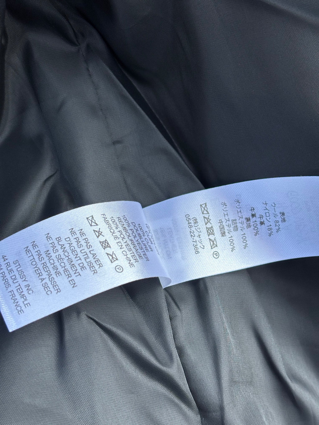 Black fabric with white care label strip and washing symbols printed