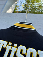Black jacket collar with yellow and white striped rib trim and partial Stussy print