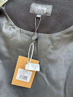 Black bomber jacket close-up of collar with size label and hanging hangtag