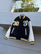 Black varsity jacket with white sleeves, yellow trim, and a front "30" patch