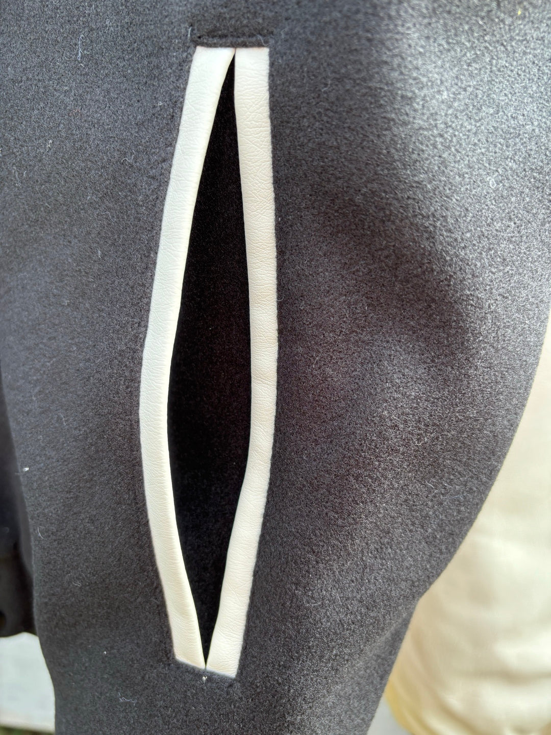 Dark fabric sleeve panel with vertical white stripe detail