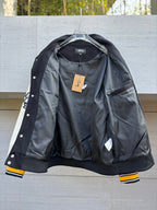 Black bomber jacket with lining view, buttons at cuffs, and a hanging price tag