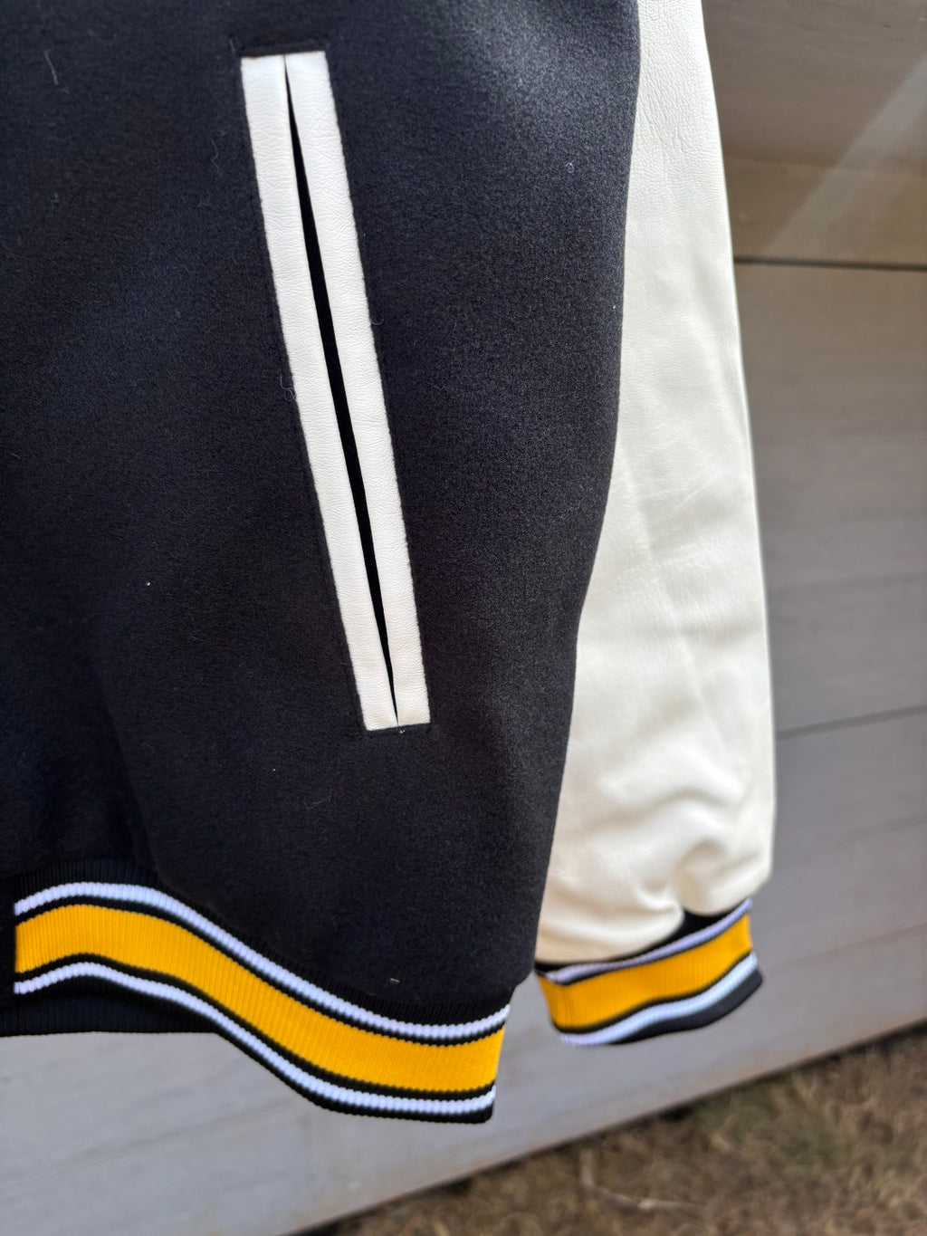 Black sleeve cuff with white stripe and yellow and blue ribbed trim