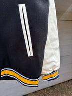 Black sleeve cuff with white stripe and yellow and blue ribbed trim