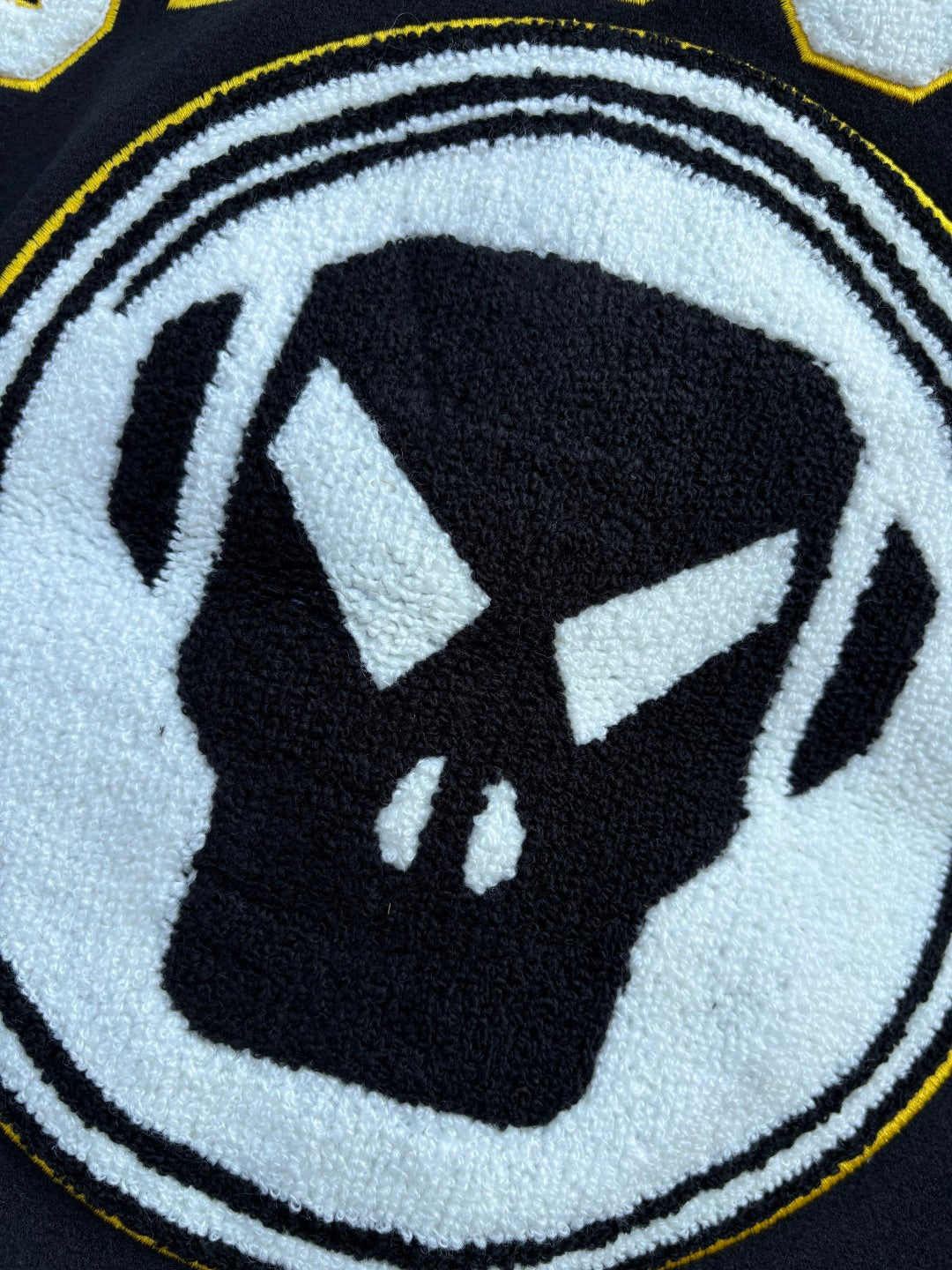 Close-up of Stussy jacket circular logo graphic in white and black