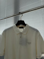Prada short-sleeve polo shirt close-up: off-white collar and partial chest logo.