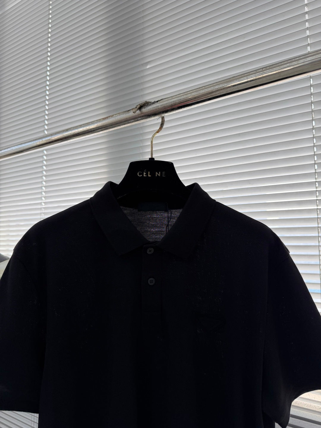 Prada polo shirt on hanger, dark short sleeves with collared neckline