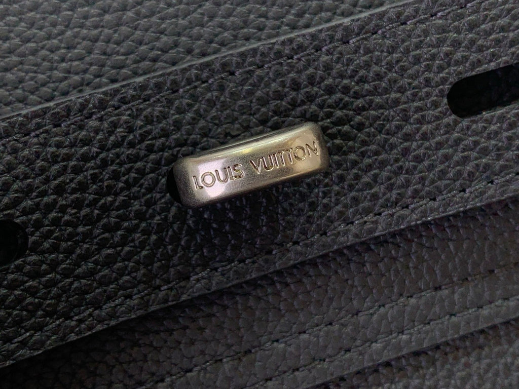 Louis Vuitton bag clasp with engraved logo on dark leather