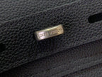 Louis Vuitton bag clasp with engraved logo on dark leather