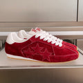 Red suede Amiri sneakers with white laces and star appliqué, low-profile sole