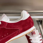Red suede Amiri sneaker with white collar, AMIRI logo on heel and lace eyelets