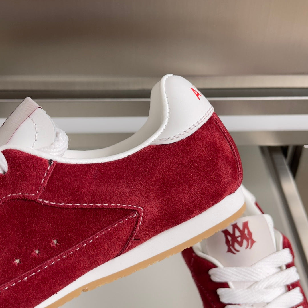 Red suede Amiri sneaker with white collar, AMIRI logo on heel and lace eyelets