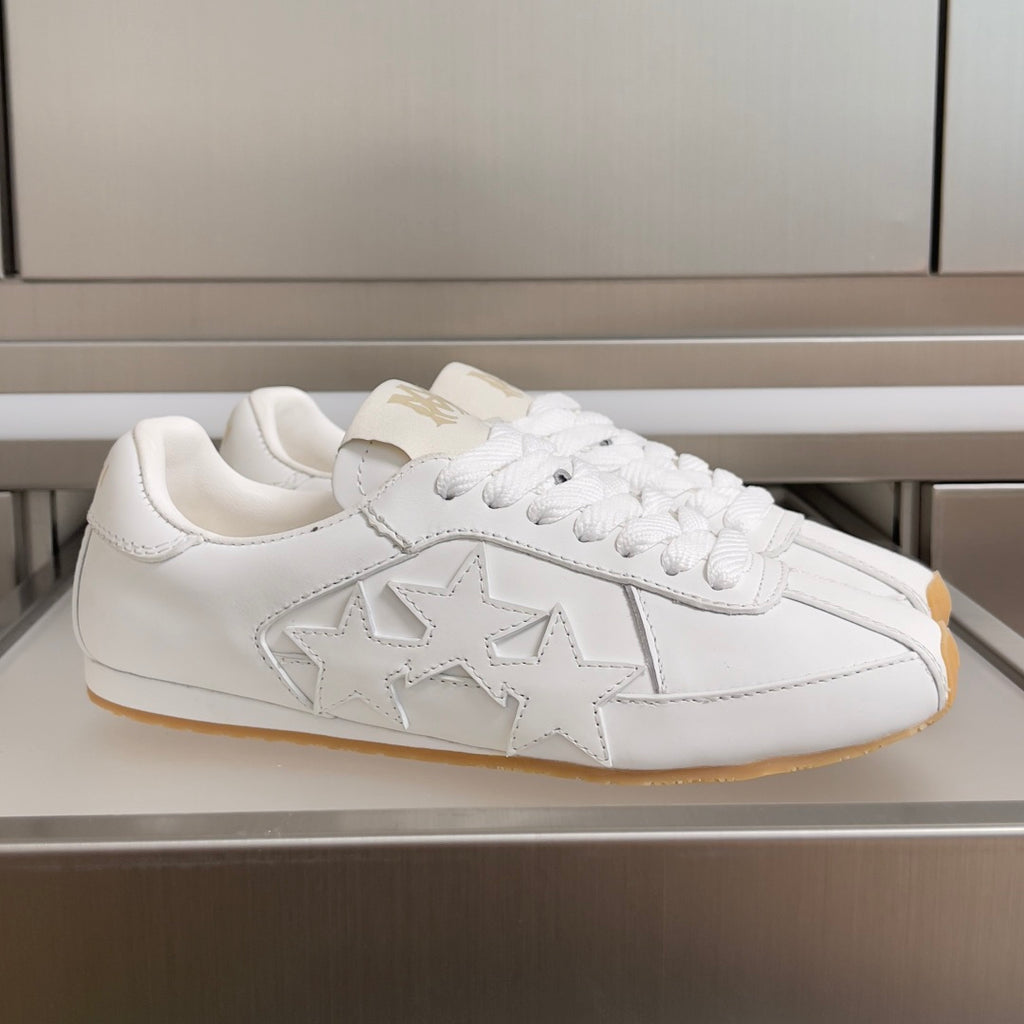 Amiri white low-top sneakers with star appliqué, lace-up front, and gum rubber sole