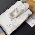 Amiri white leather sneakers with star design, thick white laces, and gum soles