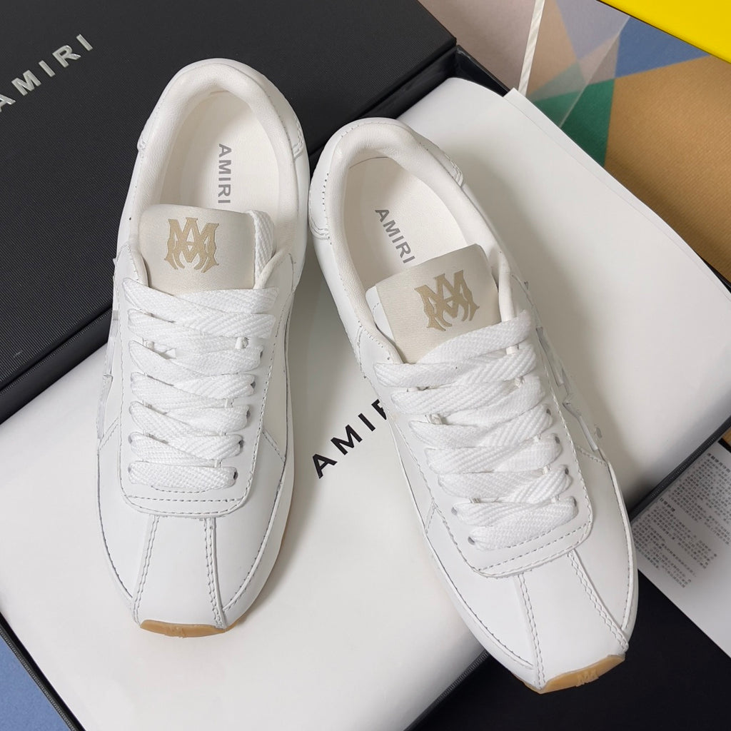 Amiri white leather sneakers with lace-up tongues and AMIRI branding on the heel