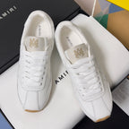 Amiri white leather sneakers with lace-up tongues and AMIRI branding on the heel