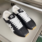 Pair of black leather sneakers with white laces and star patch on the sides
