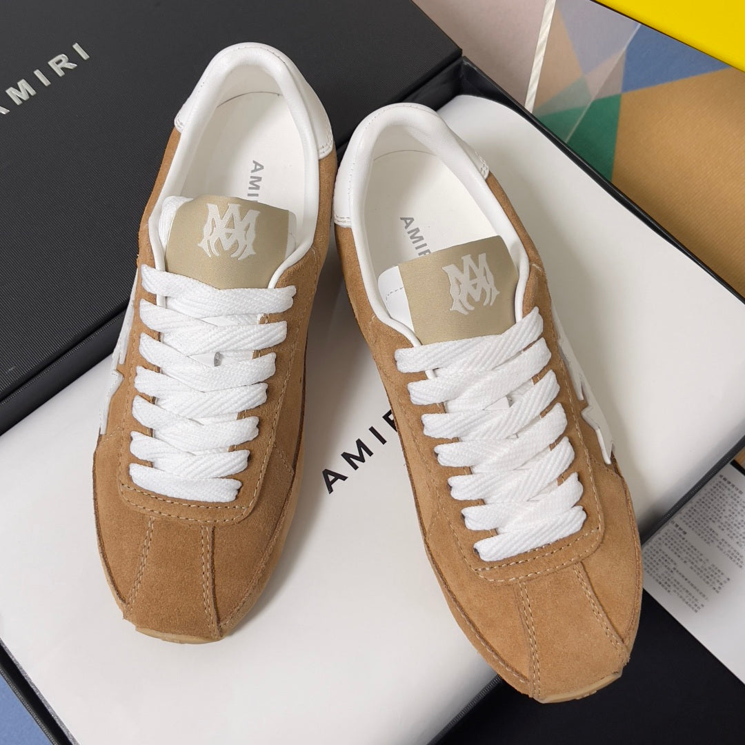 Tan suede low-top sneakers with white laces and AMIRI logo on tongue