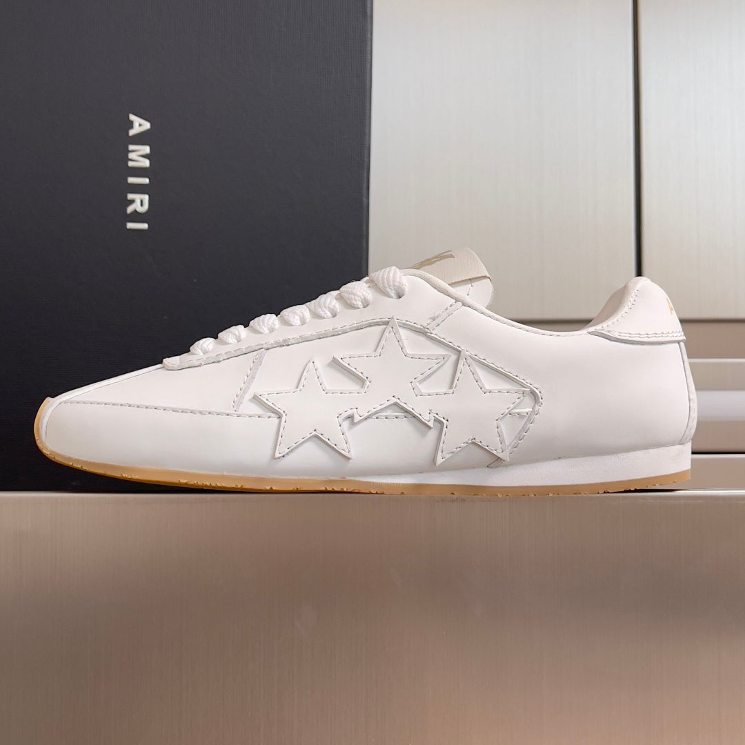 Amiri white low-top sneakers with large star detailing and lace-up closure